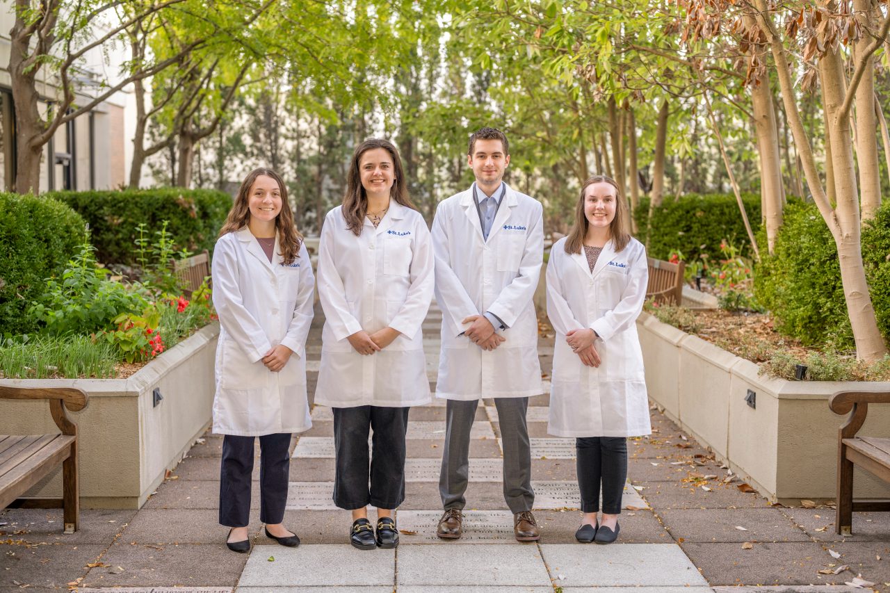 Residents standing in garden in white coats
