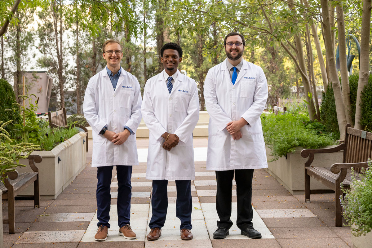 Residents standing in garden in white coats
